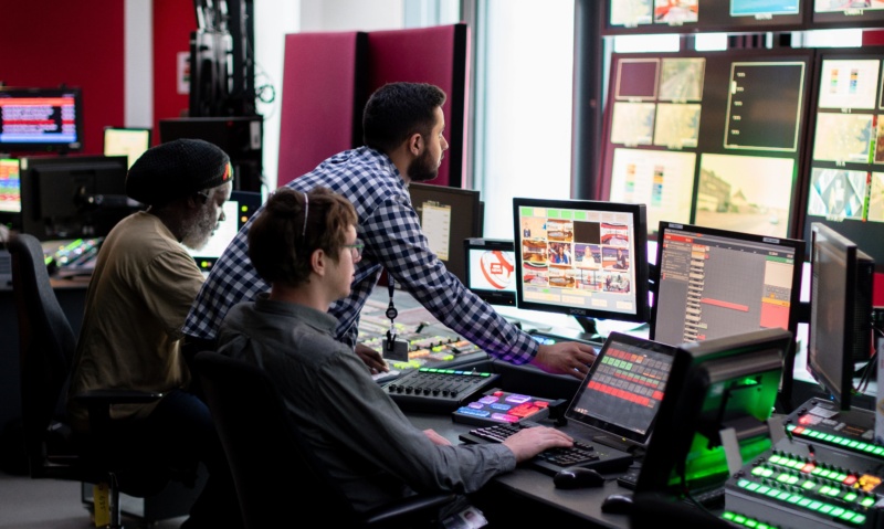 A group of 3 men using television editing tools