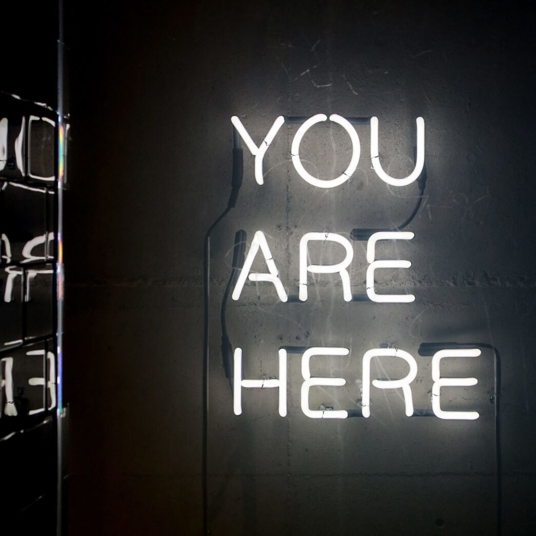 A sign made of lights saying “You are here”