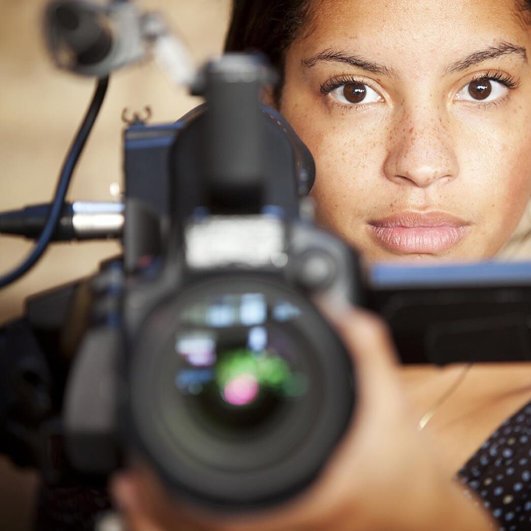 A young woman using professional filming equipment